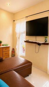 a bedroom with a bed and a tv on the wall at Nandos Places in Puerto Barrios