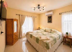 a bedroom with a bed and a dresser and windows at Nandos Places in Puerto Barrios
