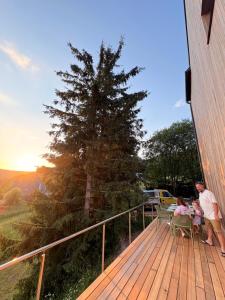 a man and two children sitting on a deck at Marcipánka in Jáchymov +9 photos
