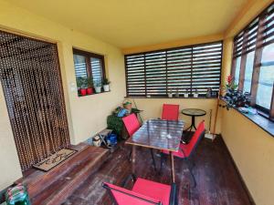 a dining room with red chairs and a table at Dedinje, ul Zorana Mitrovića 22 in Jagodina