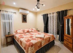 a bedroom with a bed and a dresser and windows at Nandos Places in Puerto Barrios +16 photos