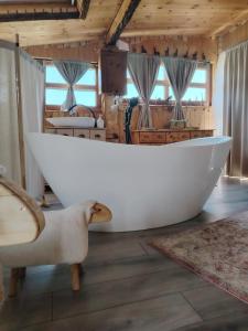 a large white bath tub sitting in a room at Lombfészek in Rezi +15 photos