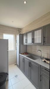 a kitchen with a sink and a refrigerator at فيولورين سويتس in Al Baha