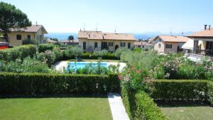 a garden with a swimming pool and some houses at Villagioia in Bardolino