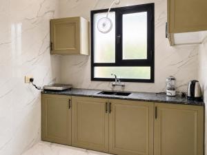 a kitchen with a sink and a window at Bin Fhaid Suites in Salalah