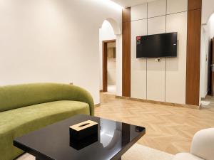 a living room with a couch and a tv on a wall at Bin Fhaid Suites in Salalah +9 photos