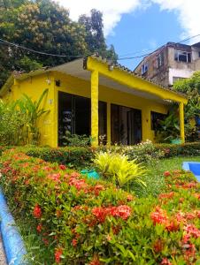 a yellow house with flowers in front of it at Palma Paraíso Hotel in Melgar