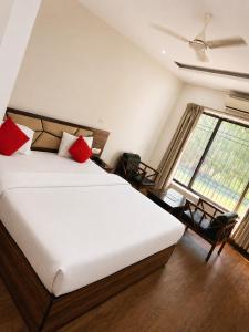 ein Schlafzimmer mit einem großen weißen Bett und roten Kissen in der Unterkunft Red Queen in Raigarh + 16 Fotos