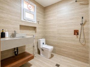 a bathroom with a toilet and a sink and a shower at Bin Fhaid Suites in Salalah