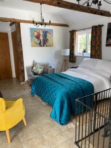 a bedroom with a bed with a blue blanket at Annexe Orchard Cottage in Mersham