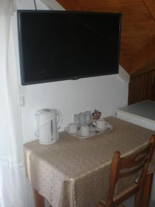 a table with a tv and cups on a table with a table sidx sidx sidx at Nicolas Rooms in Fiskardo