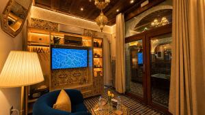 a living room with a blue chair and a television at Riad Fes Palais Bab Sahra Suites & Cooking Workshops in Fez
