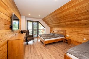 a bedroom with a bed in a room with wooden walls at Chata Alexia Oravice in Vitanová