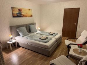 a small bedroom with two beds and a chair at ESER Hotel Restaurant in Bad Bellingen
