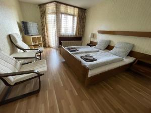 a bedroom with a bed and a couch and chairs at ESER Hotel Restaurant in Bad Bellingen