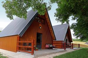 a red barn with a metal roof at Javorje24 chalets in Žabljak