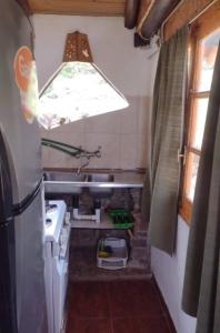 a small kitchen with a stove and a window at Cabaña Vallecitos in Ciudad Lujan de Cuyo
