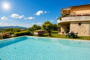 a large swimming pool in front of a house at Villa Vale in Casole dʼElsa