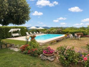 a swimming pool in a yard with flowers at Villa Vale in Casole dʼElsa