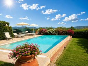 a swimming pool with flowers in a yard at Villa Vale in Casole dʼElsa
