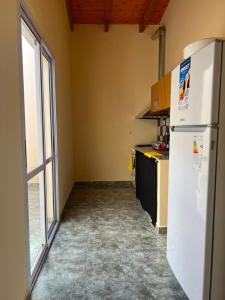 a kitchen with a white refrigerator and a window at Altos del Pissis I in Tinogasta