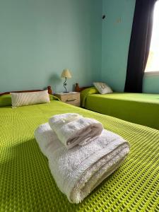 two towels are stacked on a bed in a room at Altos del Pissis I in Tinogasta