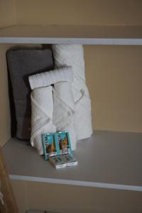 a pile of towels and a book on a shelf at Casa del Pueblo in Teotitlán del Valle