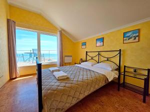 a bedroom with a bed with a view of the ocean at Великі котеджі з терасами у моря Совіньйон in Odesa