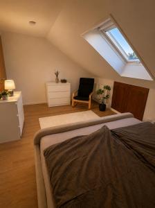 a attic room with a bed and a window at Moderne Dachgeschosswohnung in Kirchlengern