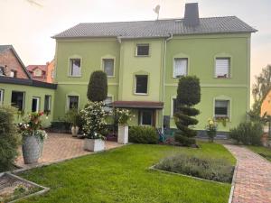 a large green house with a yard at Apartments Zur Eiche in Großräschen
