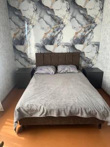 a bed in a bedroom with a marble wall at Tsovazard Life Lake in Tsovazard
