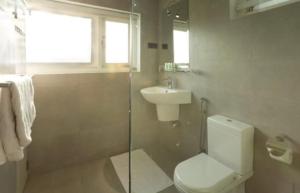 a bathroom with a toilet and a sink and a shower at Shalom Residence Kandy in Kandy