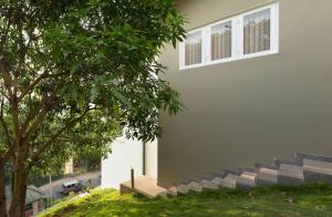 a building with stairs next to a tree at Shalom Residence Kandy in Kandy