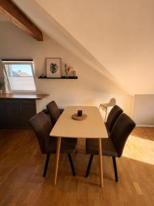 a dining room with a table and chairs at Moderne Dachgeschosswohnung in Kirchlengern +9 photos