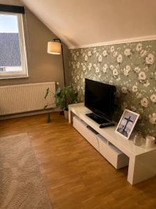 a living room with a flat screen tv on a wall at Moderne Dachgeschosswohnung in Kirchlengern
