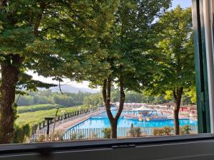 a view of a swimming pool from a window at Park Hotel Salice Terme - OltrePo Pavese in Salice Terme