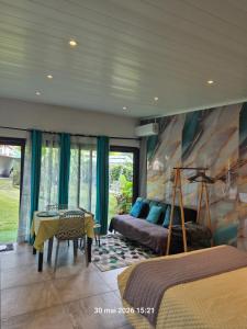 a bedroom with a bed and a couch and a table at La familiale in Salazie