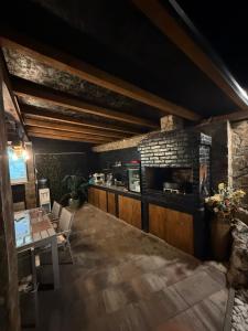a dining room with a table and a brick wall at Villa Leah in Bihać