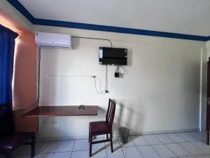 a room with a table and a tv on a wall at Alojamiento 22 dé octubre in Santa Cruz de la Sierra