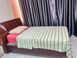 a small bed with a green and white striped sheets at Alojamiento 22 dé octubre in Santa Cruz de la Sierra