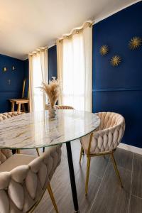 a dining room with a glass table and chairs at L'échappée Seine - Idéalement situé in Barentin +11 photos
