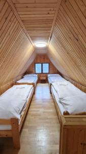 a room with three beds in a wooden house at Chata Kopánka in Moderštôlňa