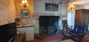 a living room with a fireplace and a tv at Les Fleurs de La Brise in Nueil-sous-Faye