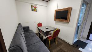 a room with a couch and a table and a television at Modern Palace Dawassah in Al Mawşil