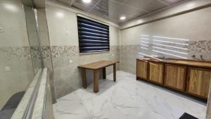 a bathroom with a sink and a wooden table at Modern Palace Dawassah in Al Mawşil +52 photos