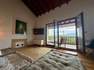 a bedroom with a large bed and a balcony at La casa de Nino in Cabanzón