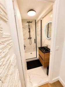 a bathroom with a shower and a sink at Résidence de la Place in Pont-du-Château