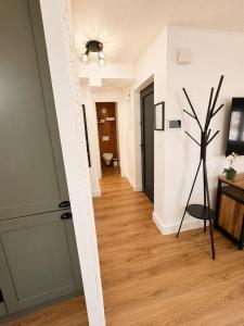 a hallway with white walls and wood floors at Résidence de la Place in Pont-du-Château