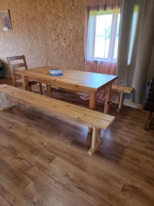 a wooden table and benches in a room at Atpūtas sēta Lībieši in Luņi