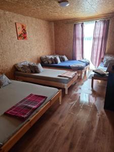 a room with three beds and a window at Atpūtas sēta Lībieši in Luņi